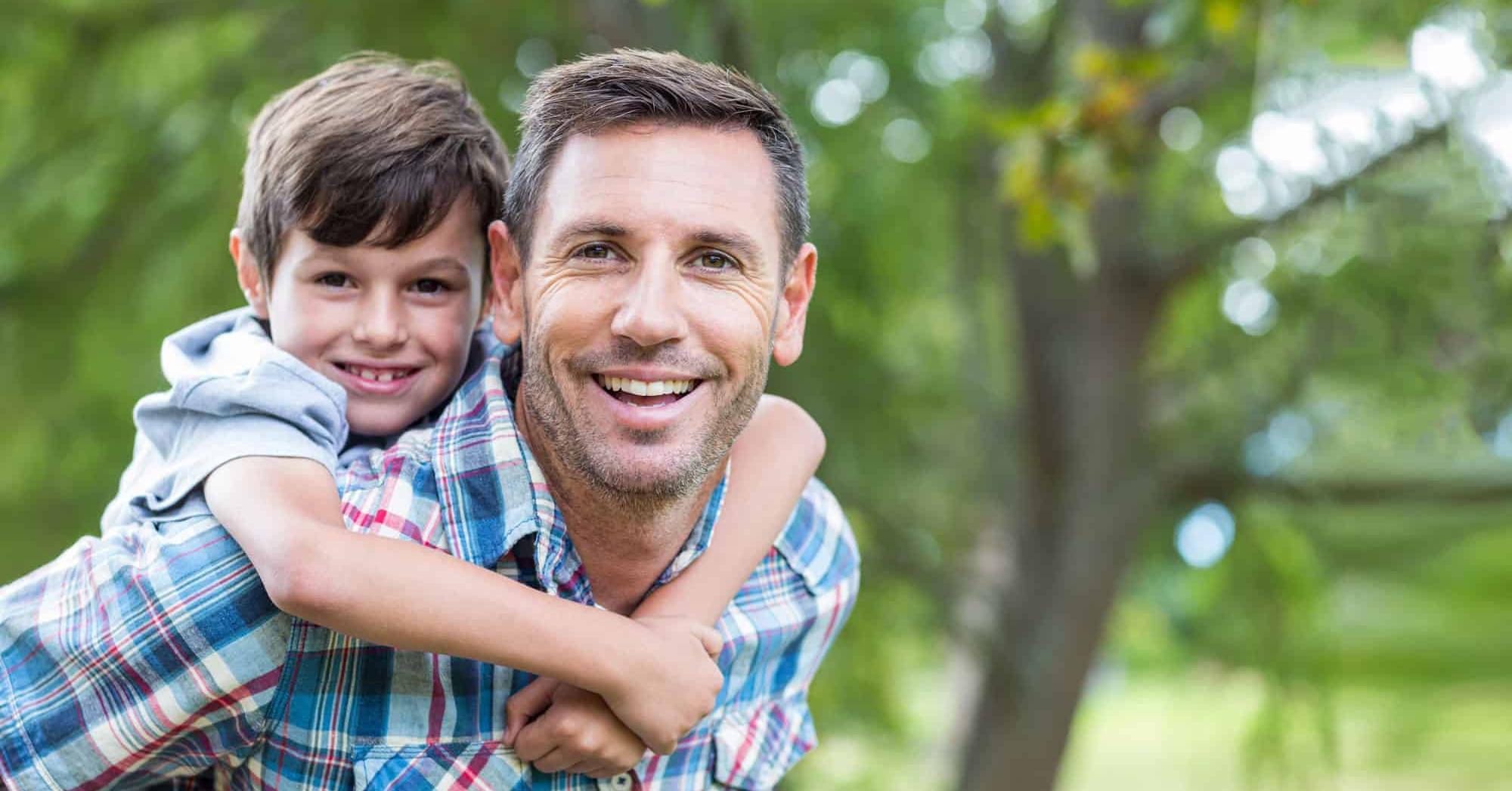 A father and son smiling together outdoors